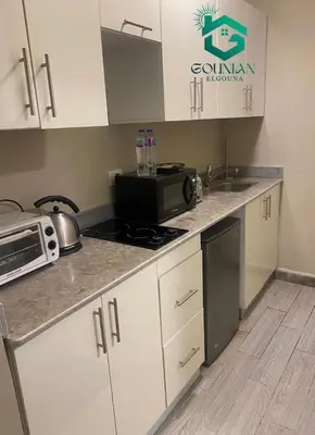 a kitchen with a microwave and a stove top oven at Cozy studio in Bali in Hurghada