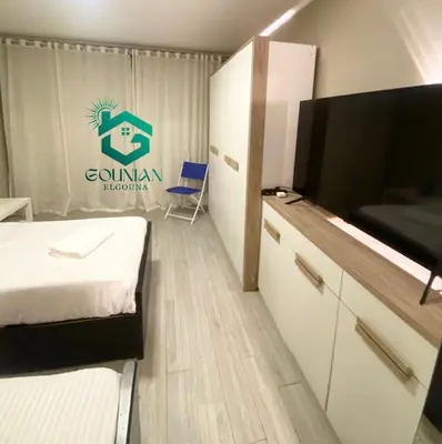 a hotel room with a bed and a tv and a room at Cozy studio in Bali in Hurghada