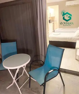 a room with two chairs and a table and a bed at Cozy studio in Bali in Hurghada