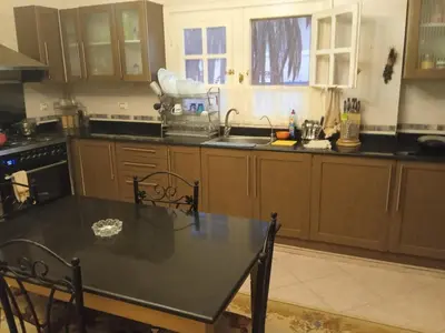 a kitchen with a table with chairs and a sink at فيلا للإيجار فى مجاويش الغردقة in Hurghada