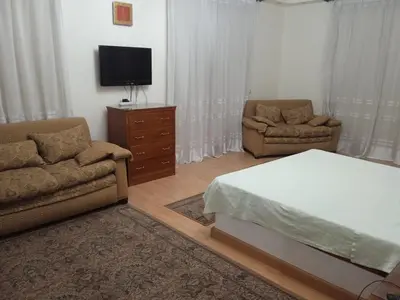 a bedroom with a bed and a couch and a tv at فيلا للإيجار فى مجاويش الغردقة in Hurghada
