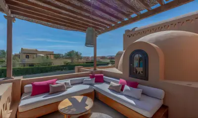 a patio with two white couches and pink pillows at Luxury Stays in West Golf El Gouna in Hurghada
