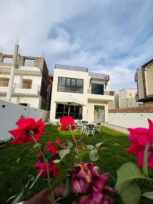 a house with red flowers in front of it at Villa Kayan in Luxor