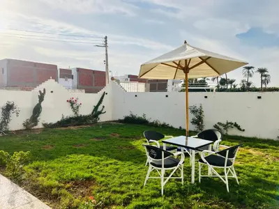 a table and chairs under an umbrella in a yard at Villa Kayan in Luxor