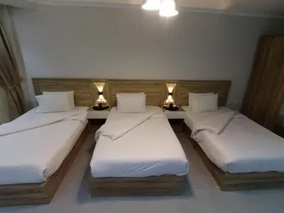 three twin beds in a room with lights on them at سكانديك ريزورت in Hurghada