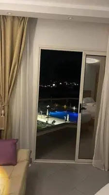 a room with a window with a view of a boat at سكانديك ريزورت in Hurghada