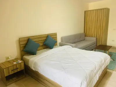a bedroom with a large bed and a couch at Sam and Sami studio apartment in Hurghada
