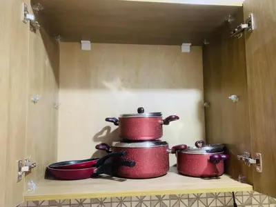 three pots and pans sitting on a shelf in a kitchen at Sam and Sami studio apartment in Hurghada