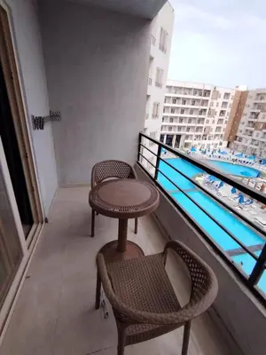two chairs and a table on a balcony with a view at Sam and Sami studio apartment in Hurghada
