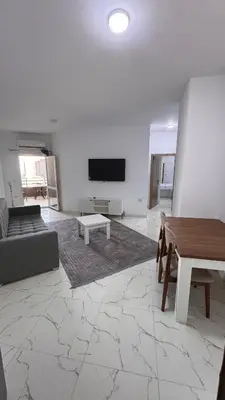 a living room with a couch and a tv on a wall at Stunning sea view Apartment in Hurghada