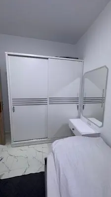 a white bedroom with a bed and a mirror at Stunning sea view Apartment in Hurghada