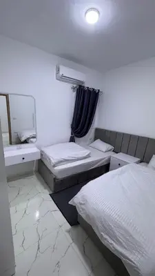 a bedroom with two beds and a sink and a mirror at Stunning sea view Apartment in Hurghada