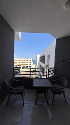 a room with a table and two chairs and a balcony at Stunning sea view Apartment in Hurghada
