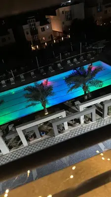 a large television screen with two palm trees on it at Fanadir L406 in Hurghada