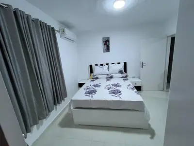 a white bedroom with a bed and curtains at Avin Resort Hurghada in Hurghada