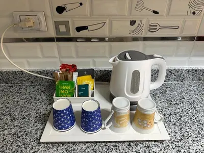 a tray with a tea kettle and cups on a counter at Avin Resort Hurghada in Hurghada