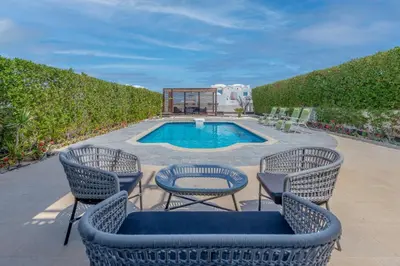 a patio with three chairs and a swimming pool at Sahlhasheesh villa with heated pool and Jacuzzi in Hurghada