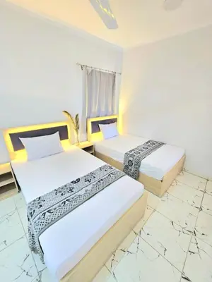 two beds in a room with white walls at Marina Views Hurghada in Hurghada