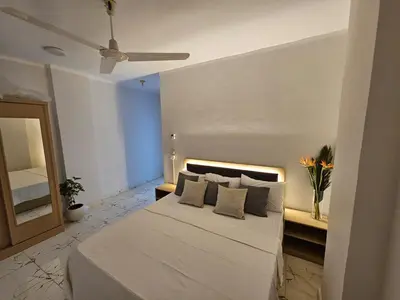 a bedroom with a white bed and a ceiling fan at Marina Views Hurghada in Hurghada