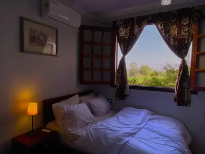 a bedroom with a bed and a window with a view at Casablanca guest house᭄ꦿ in Luxor