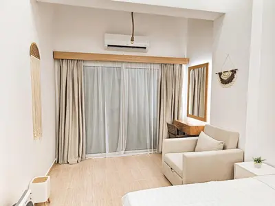 a hotel room with a couch and a window at Private Garden Studio Wi-Fi and Beach Access in Hurghada