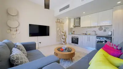 a living room with a blue couch and a kitchen at Cozy apartment in Mangroovy in Hurghada