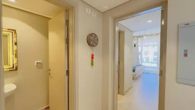 a bathroom with a door and a clock on the wall at Cozy apartment in Mangroovy in Hurghada
