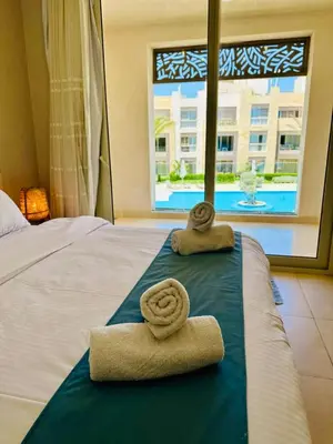 a bedroom with two towels on a bed with a window at Cozy apartment in Mangroovy in Hurghada