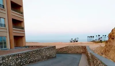 a building on the beach next to a building at Sahl hashesh Resort in Hurghada