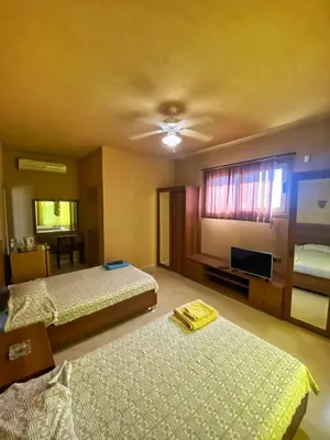 a hotel room with two beds and a television at Luxury Sea-View Villa with Private Pool with Diving center & Beach access in Marsa Alam