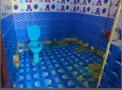 a bathroom with a blue toilet in a tile floor at Nubian night in Jazīrat Suhayl