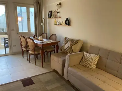a living room with a table and a couch at 2 bed rooms apartment in makadi heights in Hurghada