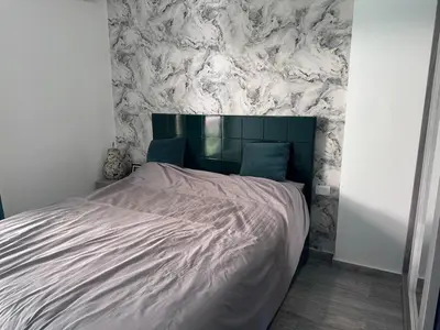 a bed in a bedroom with a marble wall at Imperial resort Hurghada, 1 bedroom luxury resort in Hurghada