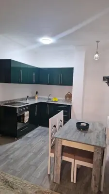 a kitchen with green cabinets and a table and a table and chairs at Imperial resort Hurghada, 1 bedroom luxury resort in Hurghada