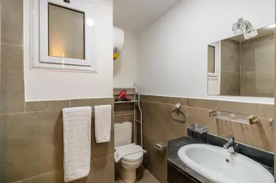 a bathroom with a sink and a toilet and a mirror at Al Saraya Sahl Hasheesh by Peaks One Bedroom Apartment With Pool View C101 in Hurghada