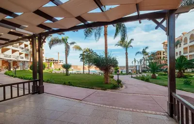 a walkway with palm trees and buildings at Al Saraya Sahl Hasheesh by Peaks One Bedroom Apartment With Pool View C101 in Hurghada