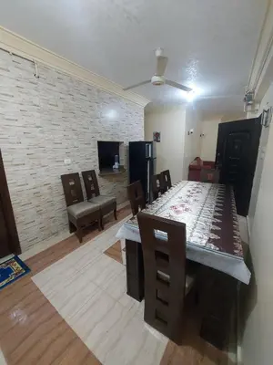 a dining room with a table and chairs and a brick wall at Entire hotel apartment overlooking the Nile in Aswan