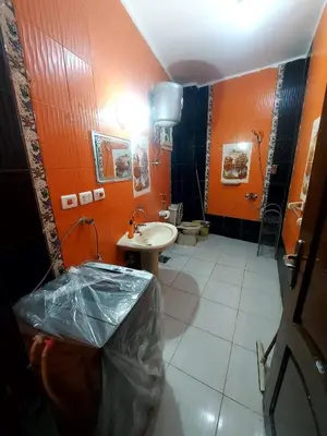 a bathroom with a sink and a toilet and orange walls at Entire hotel apartment overlooking the Nile in Aswan