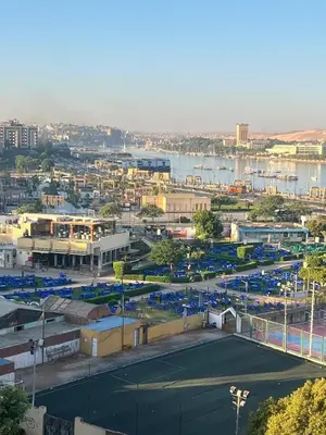 a tennis court in a city next to a body of water at Entire hotel apartment overlooking the Nile in Aswan