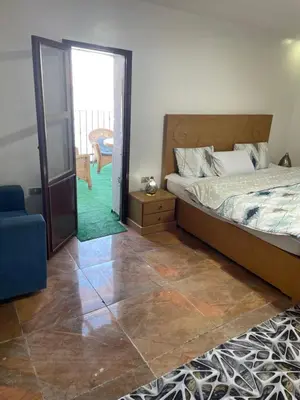 a bedroom with a bed and a door leading to a patio at Yellow House on the Nile in Luxor