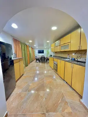 a large kitchen with wooden cabinets and a large tile floor at Yellow House on the Nile in Luxor