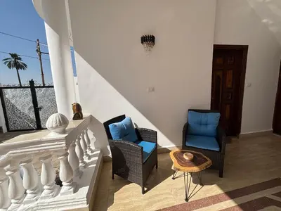 a living room with two chairs and a table at Villa Golden Mountain in Luxor