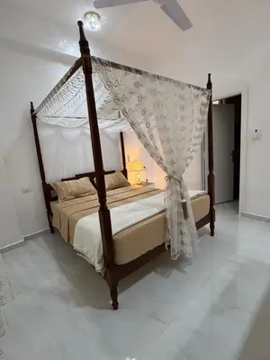 a bedroom with a canopy bed with a mosquito net at Villa Golden Mountain in Luxor