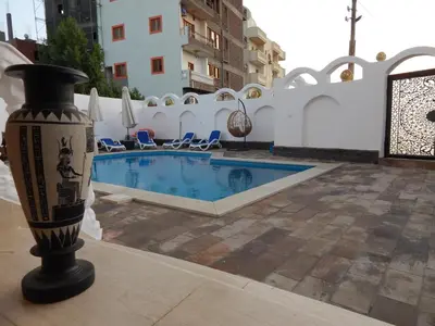 a vase is sitting next to a swimming pool at Villa Golden Mountain in Luxor