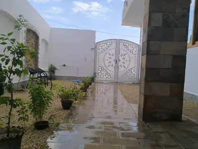 a gate to a white building with a stone walkway at King House in Luxor