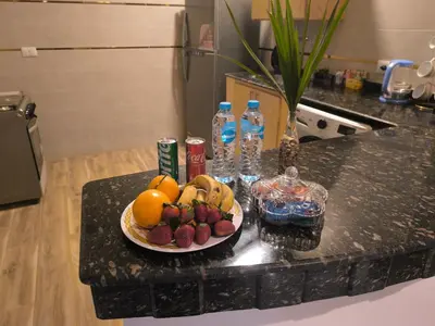 a plate of fruit on a counter with water bottles at King House in Luxor