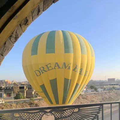 a yellow hot air balloon sitting under a bridge at King House in Luxor