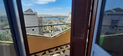 a balcony with a view of a city and water at Downtown Apartment in Aswan