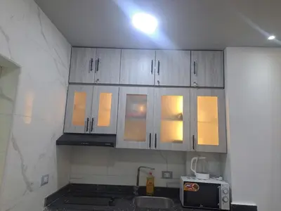 a kitchen with white cabinets and a microwave at Amazing Roof In Marina Hurghada in Hurghada