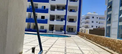 a swimming pool in front of a building at اويسيس مارينا in Hurghada